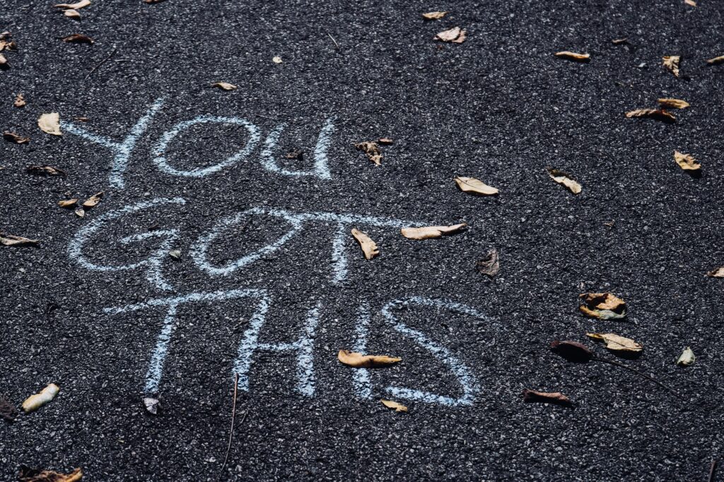 'You got this' written in white chalk on tarmac 