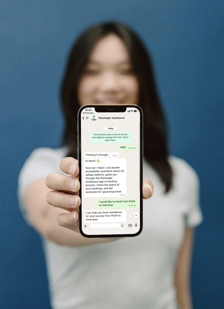 A person holding a phone showing Ask PA for train assistance on WhatsApp.