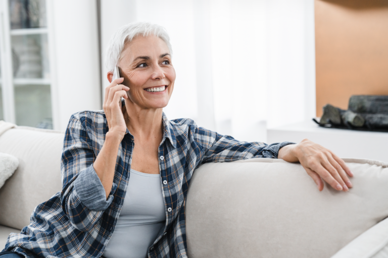 An elderly woman talking on the phone