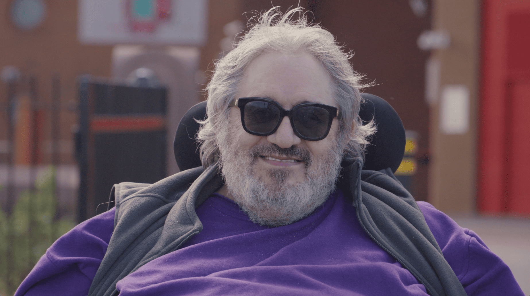 An elderly man with visual impairment wearing sunglasses